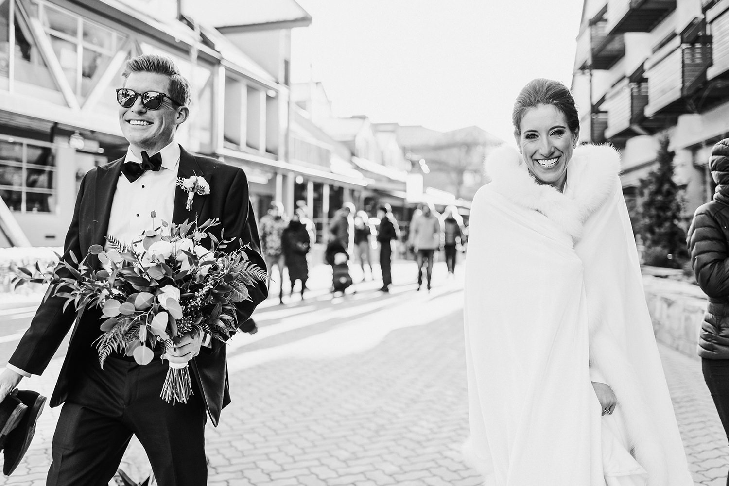 Bride and groom walk through Whistler village during their winter elopement